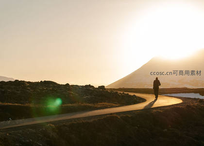 夕阳下孤独行者漫步山间小径