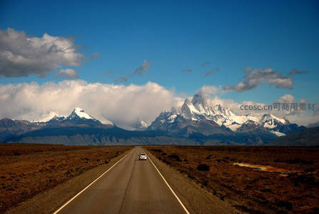 荒原公路上单车驶向雪峰之巅