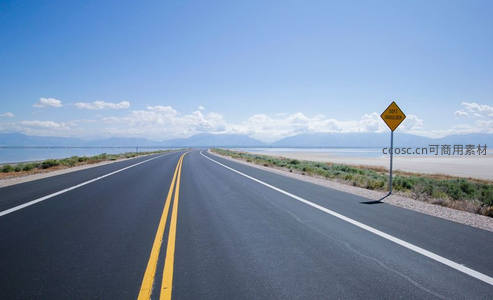 晴空万里下，公路旁立着安全警示牌