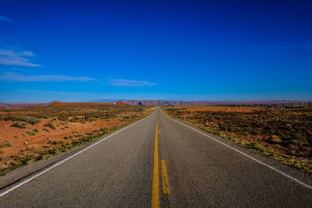 笔直公路伸向荒漠，蓝天无垠