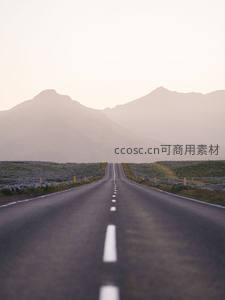 晨雾中通往山峦的笔直公路