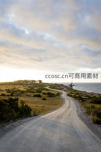 海岸边夕阳下的乡间土路与风车