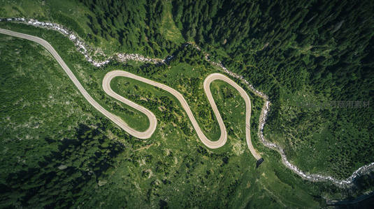 航拍蜿蜒山路如巨蛇盘踞绿野之中