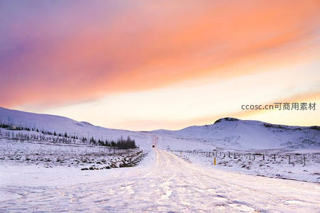 雪原公路延伸向远方，粉紫霞光染透天际
