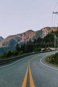 山间公路沿陡坡蜿蜒穿行林海