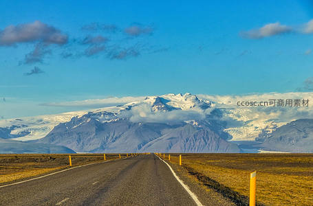 冰岛雪峰下的公路延伸至天际