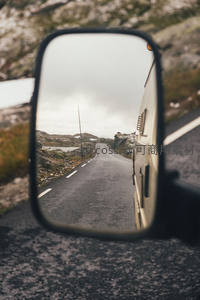 后视镜中的蜿蜒山路与远方风景