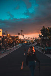棕榈树下女子漫步街景