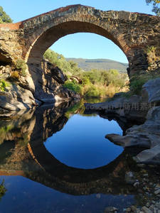 古石桥倒影如圆月，静水映山野风光
