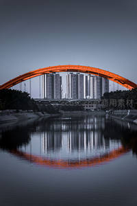 橙色拱桥倒影映城市天际线