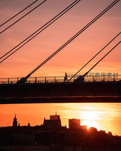 夕阳下桥上孤独行人剪影