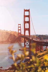 阳光洒落金门大桥与海岸线之间