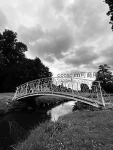古典铁艺拱桥静卧溪流之上云影斑驳