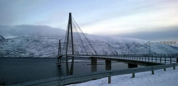 雪覆山峦间现代斜拉桥横跨静谧湖面