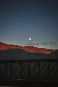 月升山巅时铁桥剪影下的静谧秋夜