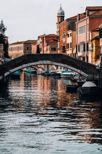 威尼斯运河拱桥下的彩色建筑倒影