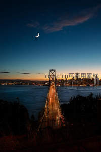 夜幕弯月下的城市桥梁车流