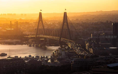 金色晨曦中的悉尼海港大桥车流涌动