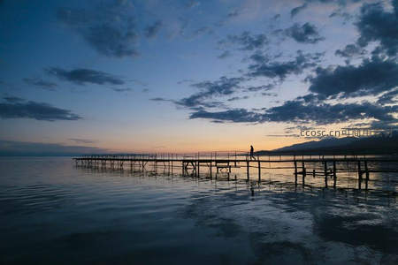 暮色湖面长桥孤影，一人独行天地间