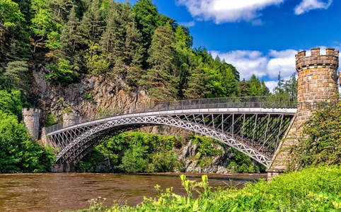 绿林掩映古堡桥，铁骨横跨碧水间