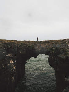 孤影伫立海岸天然石拱