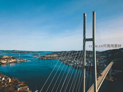 航拍视角下的现代斜拉桥与海湾城镇