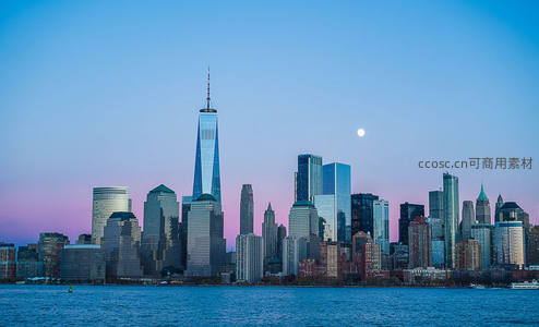 黄昏时分的城市剪影，月亮高悬天际