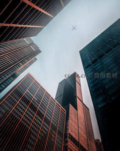 都市峡谷中飞机掠过，仰视高楼与天空