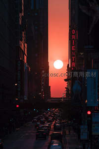 日落时分城市峡谷中太阳悬于楼宇间