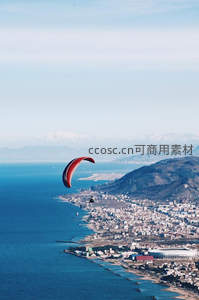 滑翔伞翱翔于海岸城市上空