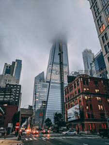 雾气缭绕摩天楼顶，城市街景车水马龙