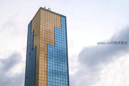 现代摩天大楼玻璃幕墙在云层下闪耀