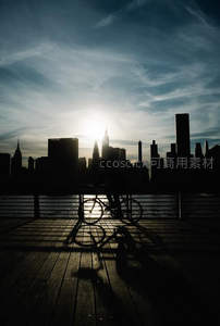 剪影骑行者与城市日落交响