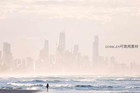 海边冲浪者遥望朦胧都市