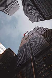 仰望摩天楼群与飘扬的旗帜