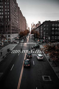 秋日街景，车辆行人穿梭于城市十字路口