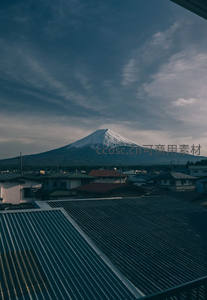 富士山静立云层之下，小镇屋顶映衬雪峰壮丽