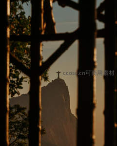 铁栅栏后基督像剪影山巅