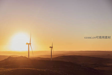 日落时分山丘上的风车剪影