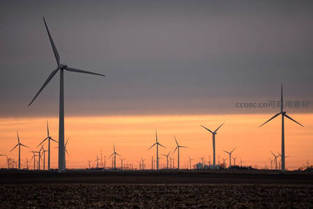 日落时分田野上风车剪影的静谧景象