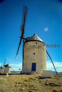 西班牙古老白墙风车在蓝天下的沧桑之美