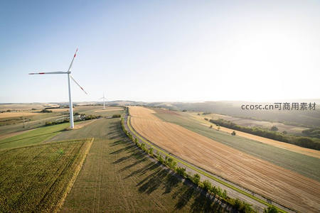 航拍视角下蜿蜒公路旁的风力发电农场