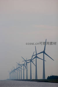 水边成排的现代风力发电机