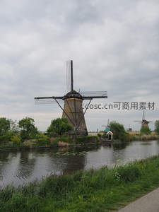 运河边静谧风车，绿树掩映古典风情