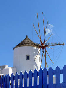 蓝天下白色风车与蓝色栅栏