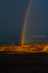 荒漠上空彩虹与风车阵列的奇观