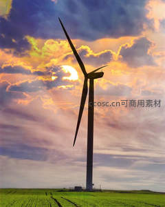 夕阳下田野中的巨型风力发电机