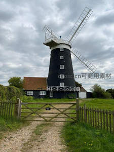 黑墙白窗古风磨坊矗立绿野间