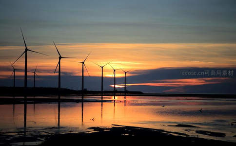 金色日落时分海岸线上风车的壮丽剪影