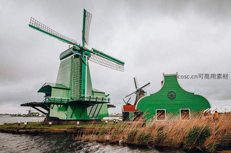 绿色风车与特色屋舍临水而立